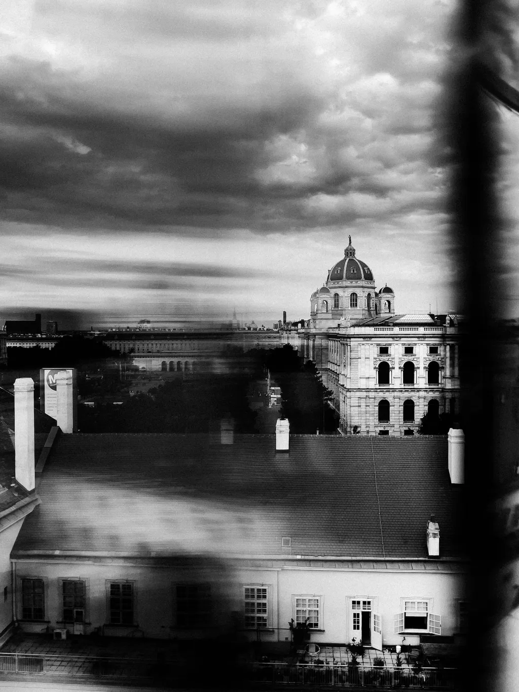 Blick über die Dächer Wiens auf die Kuppel des Naturhistorischen Museums unter dunklen Wolken